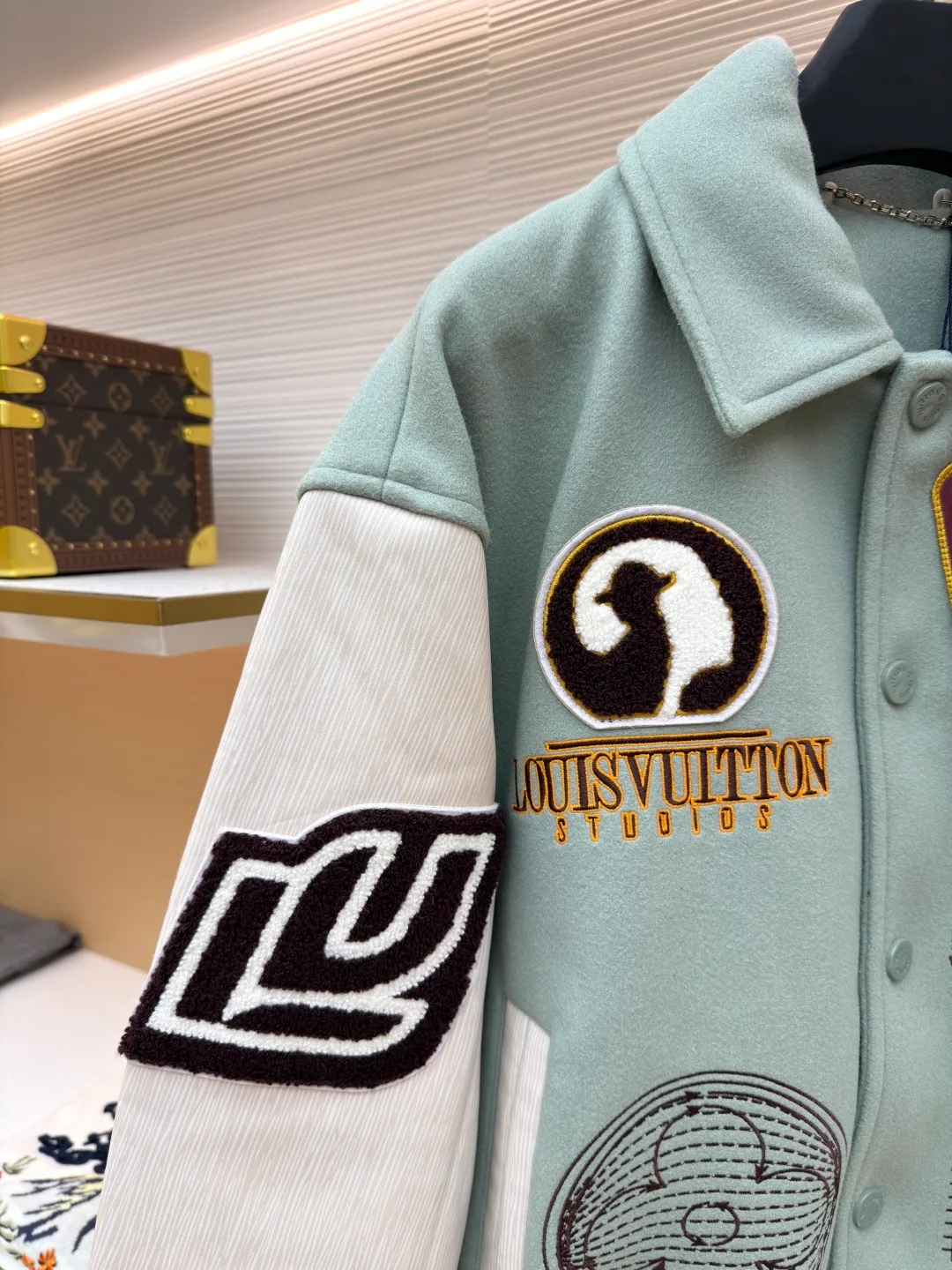 LOUIS VUITTON letter pattern patch printed color block baseball jersey ●Original version: 38999 purchase and development ●Item number: 1681672-D15 ●Fabric: sheep wool fabric ●Technology: printing production ●Color: green ●Version: fitted version ●Weight: about 1220 grams ●Size: 46-48-50-52 ●Description: This jacket is made of high-quality wool blended fabric, which is soft to the touch and has excellent warmth retention. The overall design adopts a lapel design, and the collar, cuffs and hem are all ribbed, with moderate elasticity, comfortable to wear and not easy to deform. The main part uses multi-color splicing technology. The gray and white splicing lines are smooth and natural, showing superb tailoring technology. The patterns on the chest and sleeves are embroidered and appliquéd, with distinct layers and a strong three-dimensional effect. Multi-colored silk threads are interwoven during the embroidery process to ensure that the pattern is clear and durable. The buttons of the jacket are made of metal, with a smooth surface and not easy to fade. The splicing of the shoulders and sleeves adopts seamless technology, with smooth and natural lines without excess threads. The overall workmanship is fine, and every stitch is even and neat, reflecting the high-quality production process. The overall wiring is straight and delicate, the fabric is comfortable and soft, and the color is consistent without color difference. It can be matched with the same style to create a fashionable look and control various occasions. Customized accessories, complete with three standards, same style for men and women!